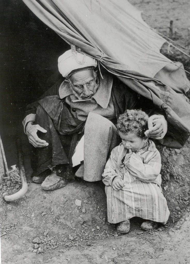 Palestinian man and child fleeing the persecution and massacres of their villages during the 1948 Nakba by Jewish terrorist groups in Palestine